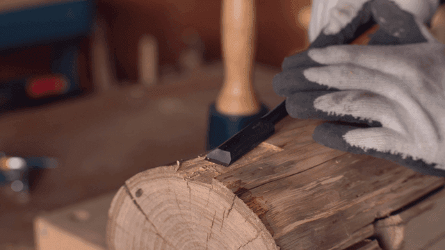 작업장에서 끌로 나무 조각하기