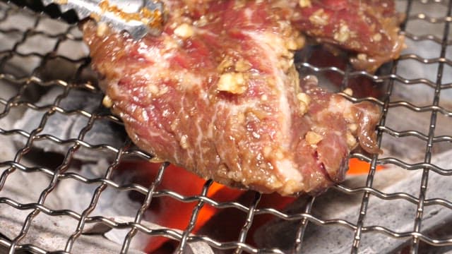 Grilling Marinated Beef Slices over Red Hot Charcoal