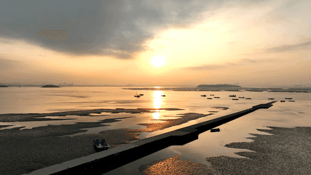 고요한 바다 위의 일몰과 배들