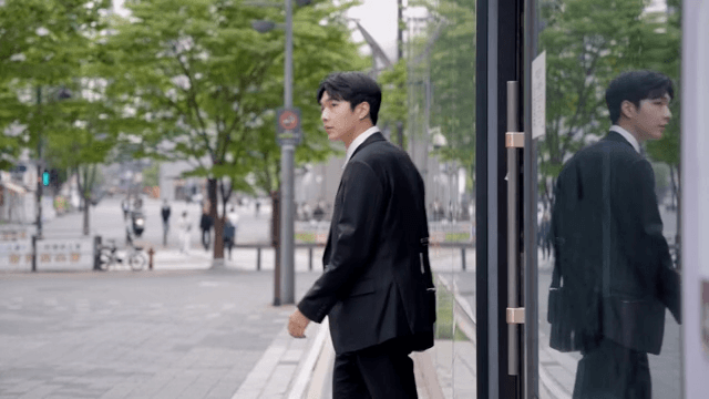 건물을 나서는 직장인 남성