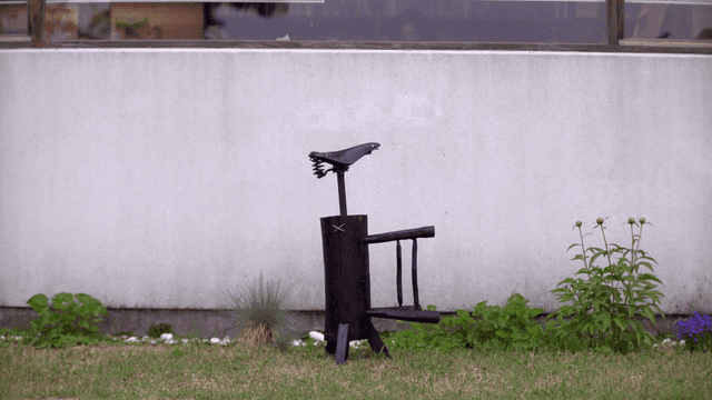 Unique wooden bicycle sculpture in a garden