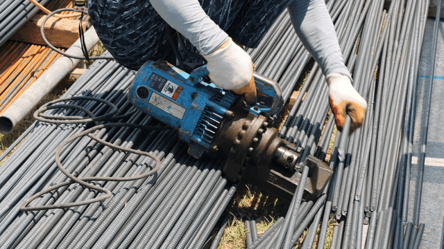 현장에서 철근 절단기를 사용하는 작업자