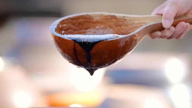 Pouring Soy Sauce from a Wooden Bowl