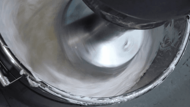 금속 그릇에서 섞이는 크림과 버터