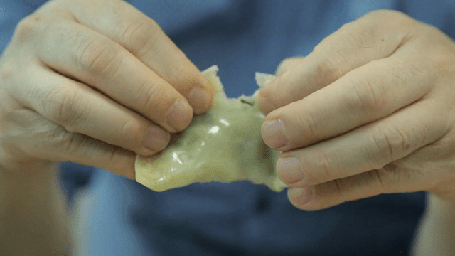 손으로 만두를 찢는 장면