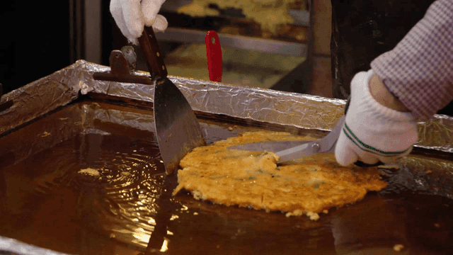Mung bean pancakes cut with scissors on iron plate