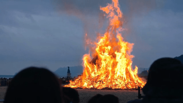관중이 있는 해변의 큰 모닥불