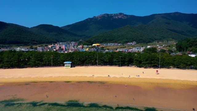 산 아래 펼쳐진 해안 마을과 잔잔한 바닷가