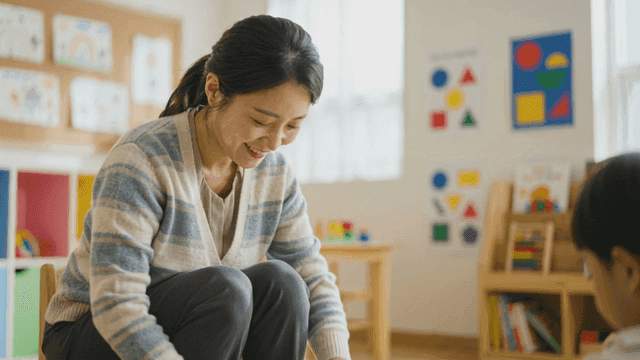 Kindergarten teacher talking to child in classroom