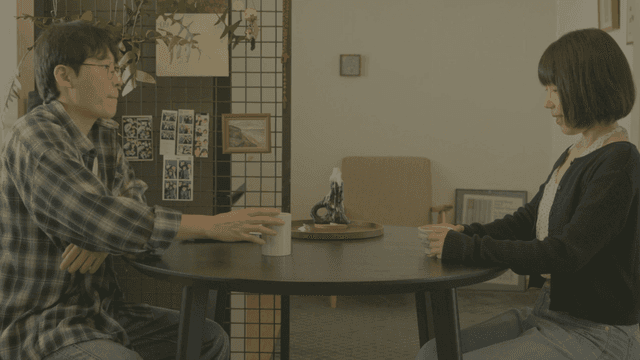 집 식탁에 앉아 대화하는 두 사람