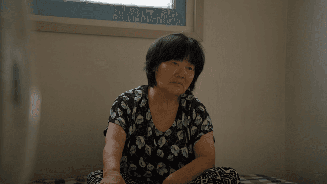 An elderly woman sitting indoors