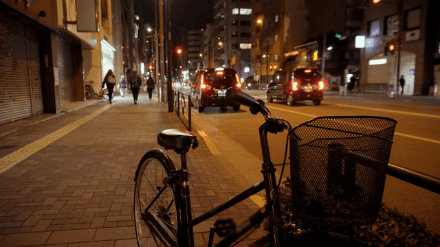 Night street with parked bicycle and cars