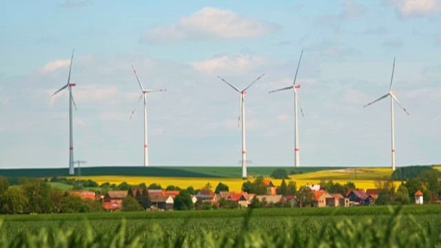 시골 집과 들판에 서 있는 풍력 발전기