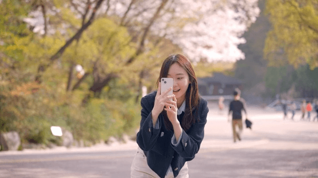 벚꽃이 핀 공원에서 사진을 찍어주는 여성