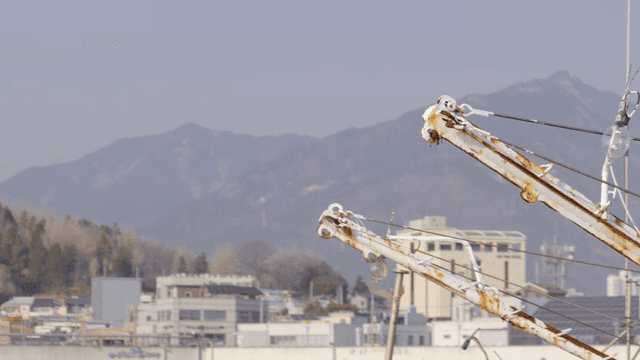 배경에 산이 있는 바다 위 배의 어업 장비