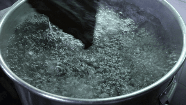 Stock pot placed in boiling water in large pot