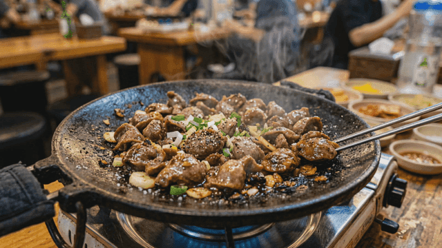Sizzling stir-fried chicken gizzards on hot iron plate