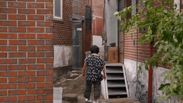 골목길을 걷는 노인 여성