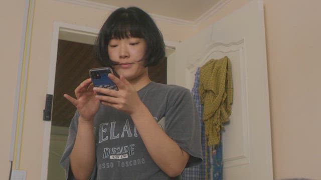 아늑한 방 안에서 핸드폰에 집중하는 여자