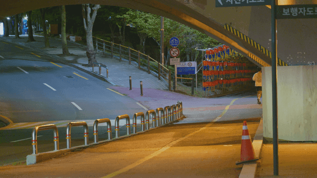 밤에 다리 아래 도로 옆 산책로에서 달리는 남자