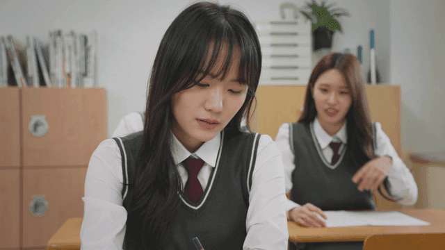 뒷자리에서 장난치는 두 학생과 괴로워하는 학생