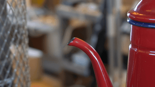 증기가 피어오르는 붉은 주전자의 입구