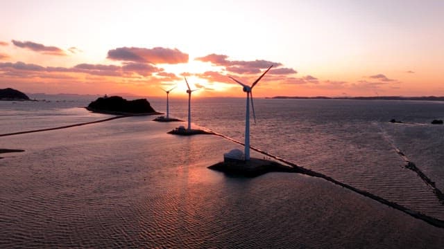 Wind turbines at sea during sunset