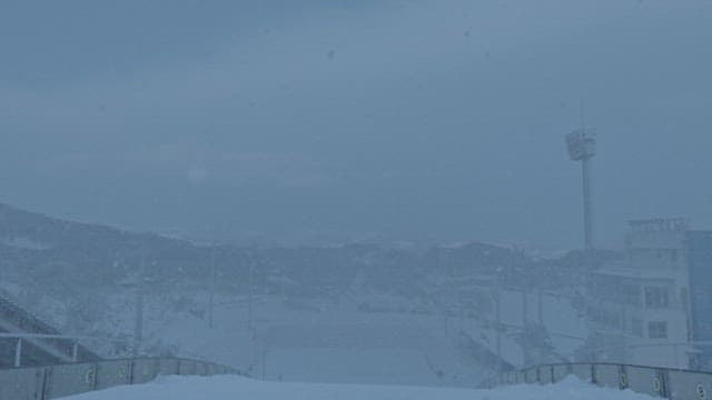 눈보라 속에서 날아오른 스키 점프 선수