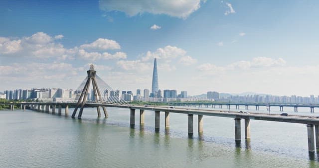 Bridge over a river with a city skyline
