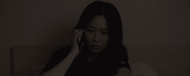 어두운 방에서 전화하는 여성