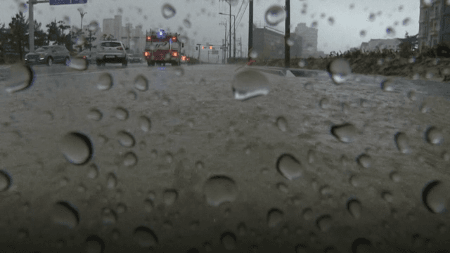 차와 소방차가 있는 비 오는 도시 거리