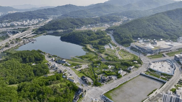 A cityscape with surrounding mountains and a lake