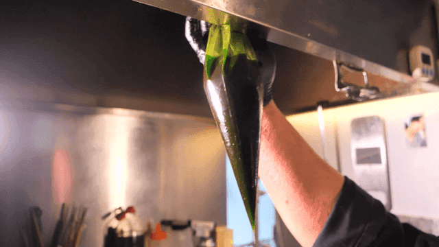 Chef preparing green sauce in kitchen