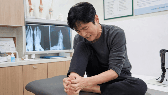 Male patient holding his foot in pain