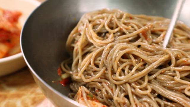 젓가락으로 비빔 냉면을 비비는 모습