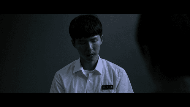 Male student being interrogated in dark room