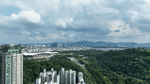 Cityscape with high-rise buildings and greenery.