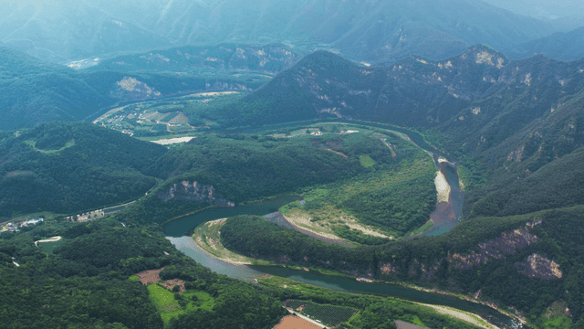 Aerial view of lush green mountains and winding river