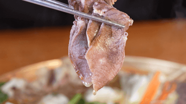 Piece of stew beef held with chopsticks