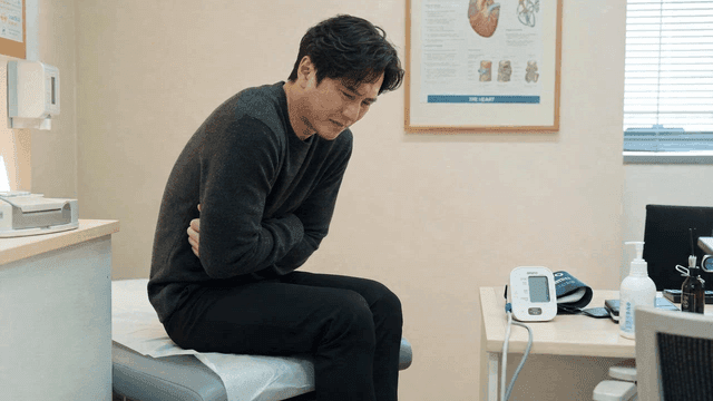 Man suffering from abdominal pain in doctor's office