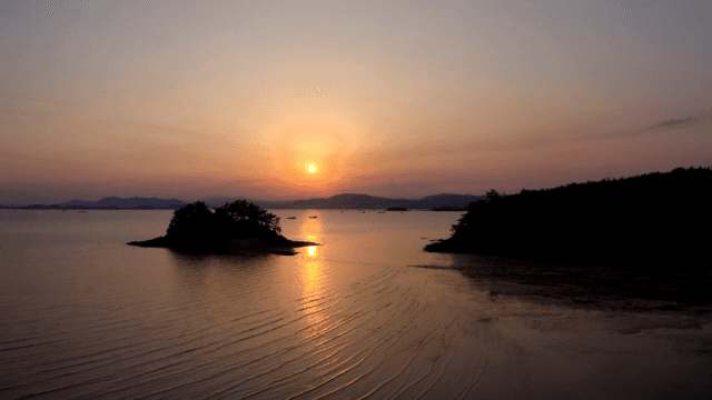 섬이 있는 고요한 바다의 일몰