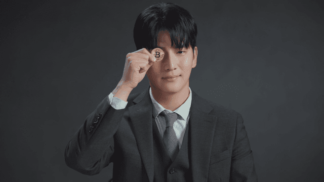비트코인 동전을 들고 있는 정장 남성