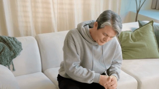 무릎을 잡고 불편해하는 남성