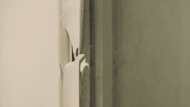 Close-up of a window frame with peeled sealant