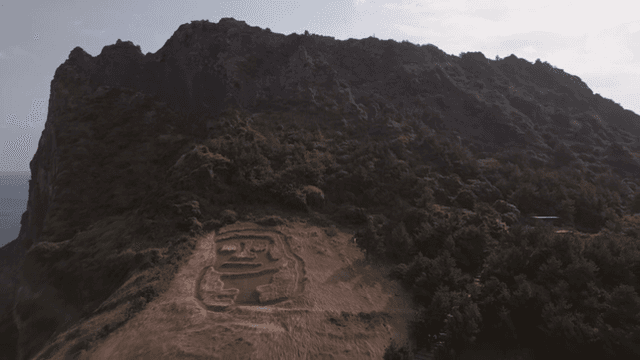 A scenic mountain with a carved field