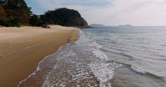 파도가 밀려와 부서지는 평화로운 해안가