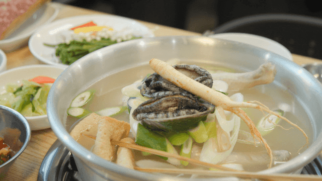 Samgyetang with side dishes, ginseng, and abalone