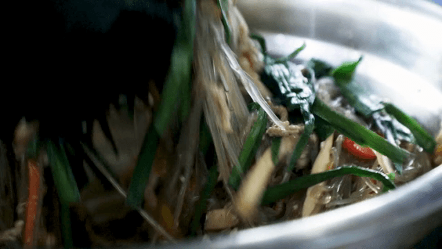 신선한 채소와 잡채를 섞는 장면