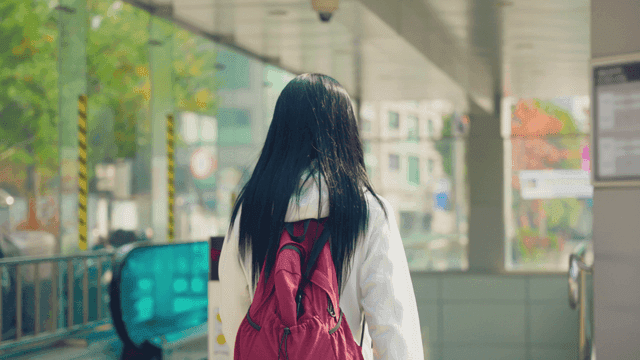 배낭을 메고 지하철 타러가는 여성