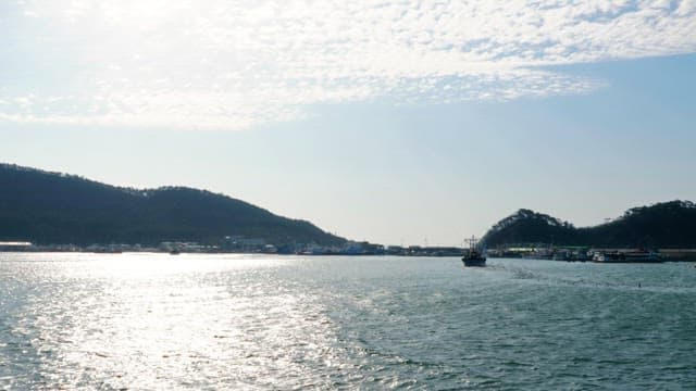 맑은 하늘 반짝이는 물결위로 지나가는 배